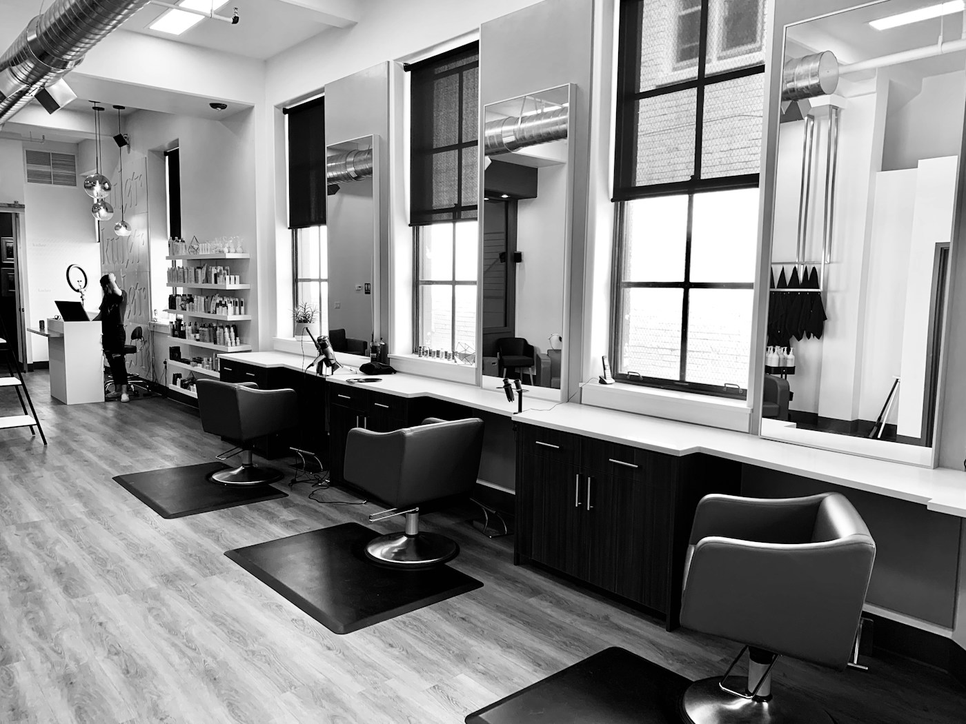 A row of barber chairs on our floor. Brick, green lamps, a chair waiting.