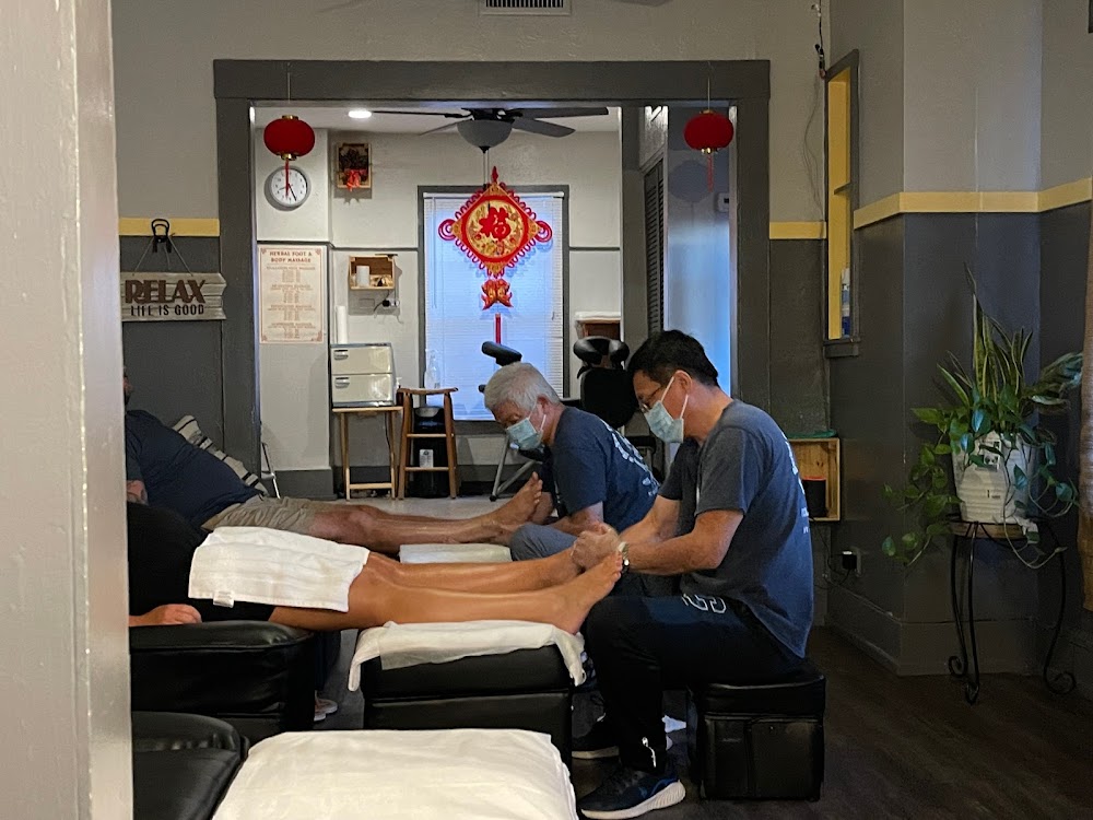 Two of us working feet in the charcoal room, red lanterns in the doorway, white towels on the ottomans