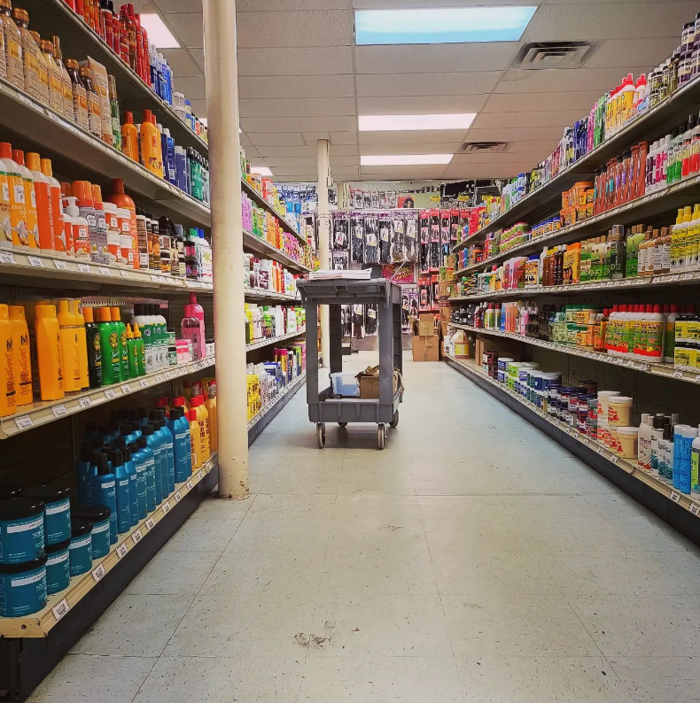 A center aisle of hair care, with weaves and extensions on the back wall