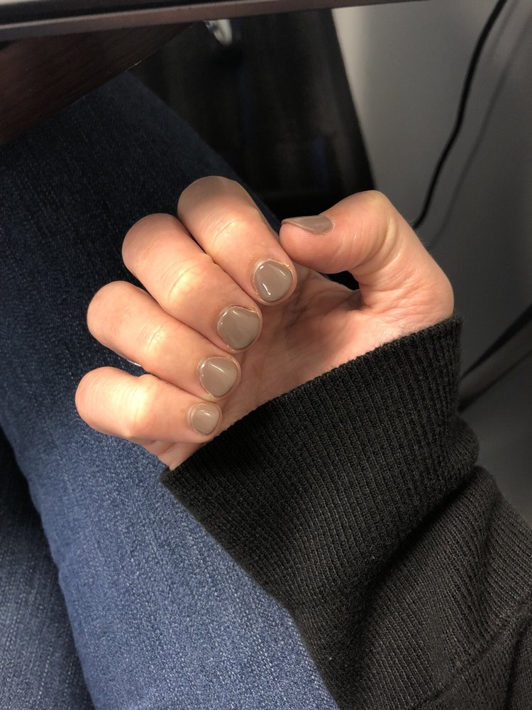 Short glossy taupe manicure on a right hand.