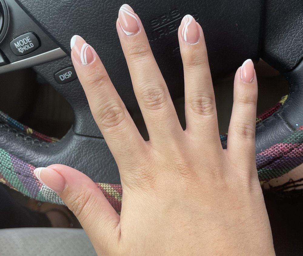 Nude oval nails with thin white swirl art.