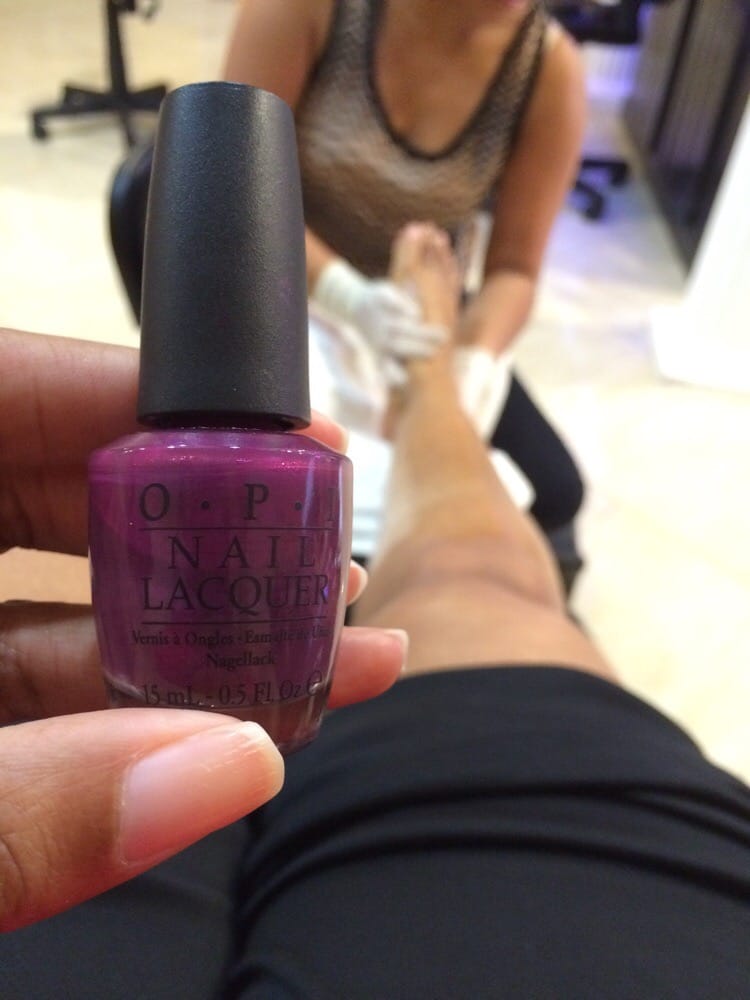 A bottle of magenta lacquer in our shop, a pedicure going on behind.