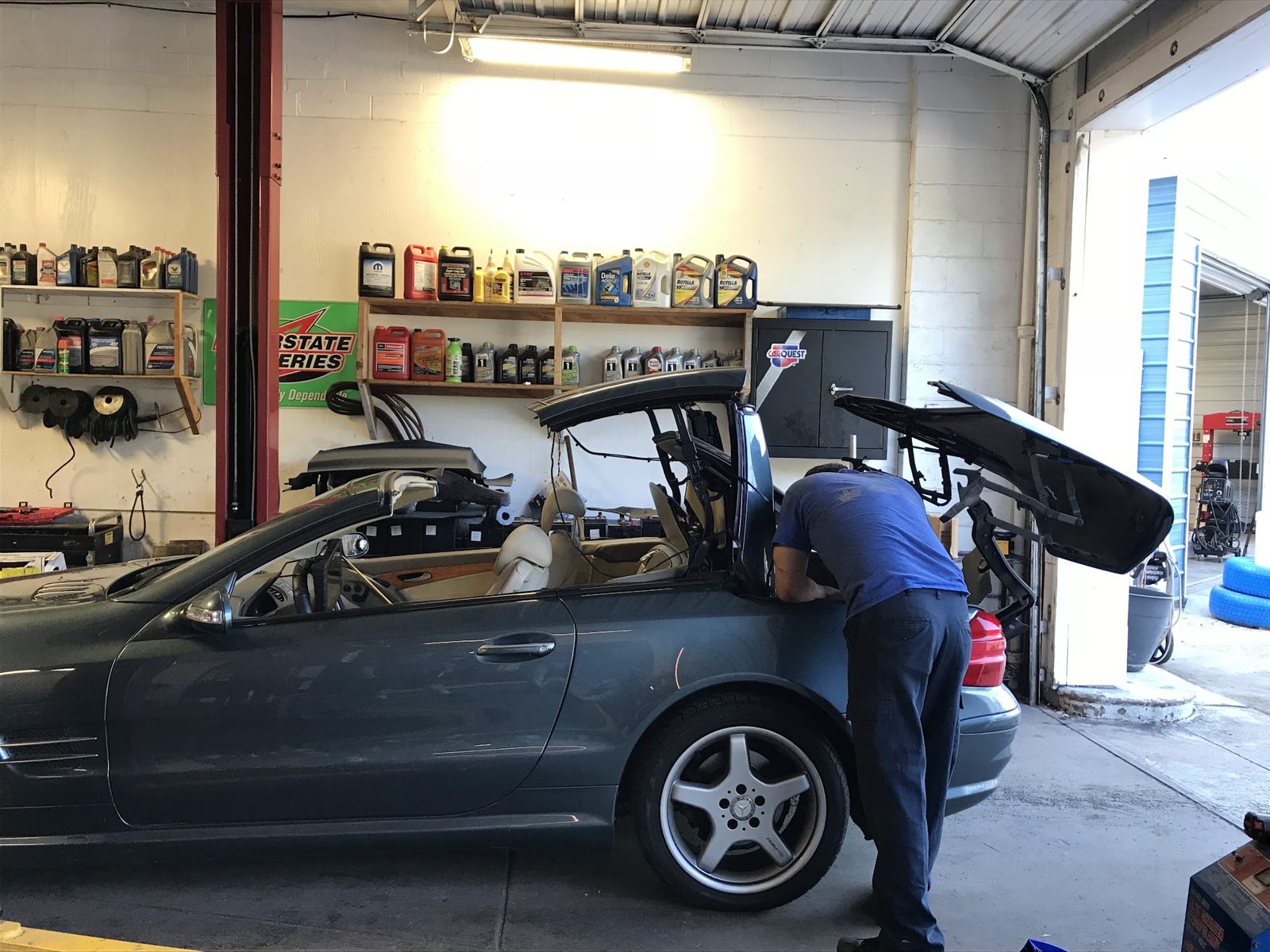 Work in our bay on a convertible, oil on the shelves behind us