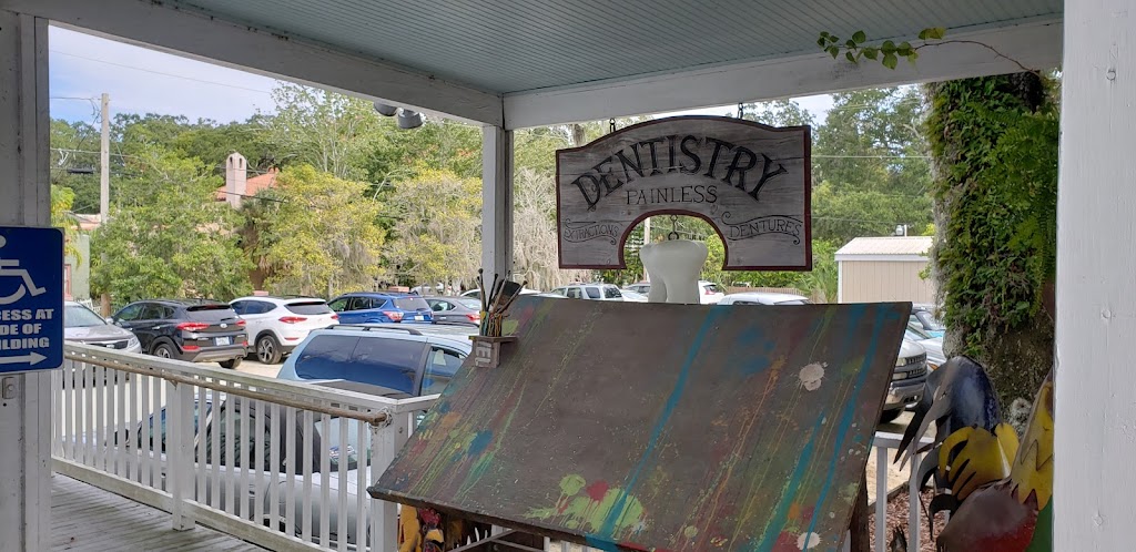 Paint-splattered easel and a hand-lettered dentistry sign on our porch