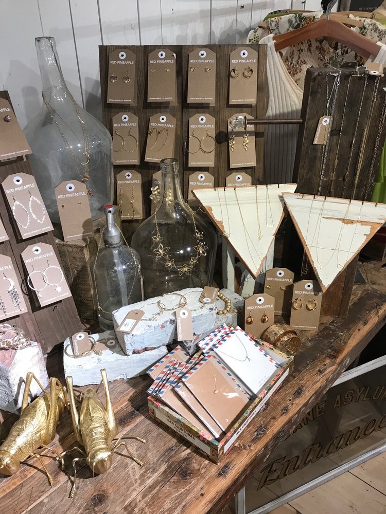 Necklaces hanging on bottles and earring cards on wooden boards
