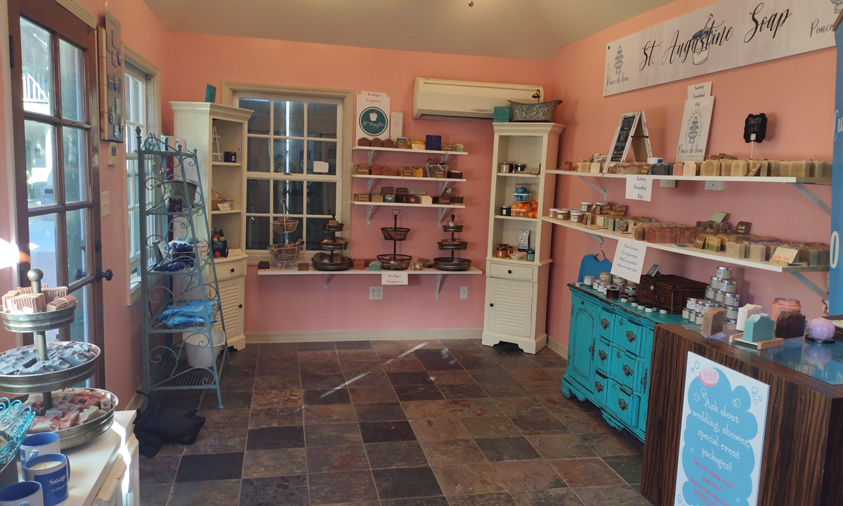 Inside our shop: pink walls, the St. Augustine Soap banner, and bars on the seafoam dresser