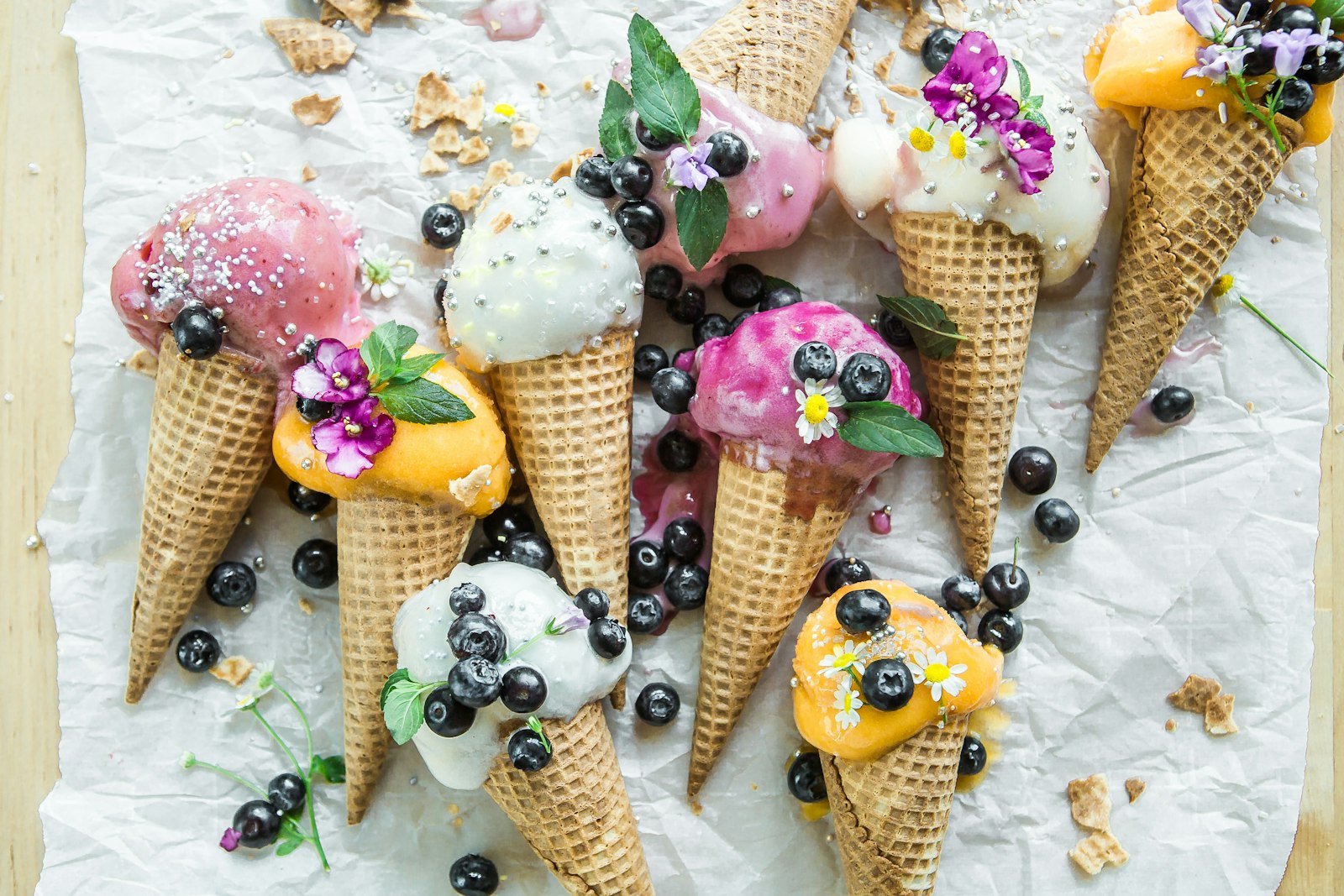 Waffle cones with fruit scoops on paper