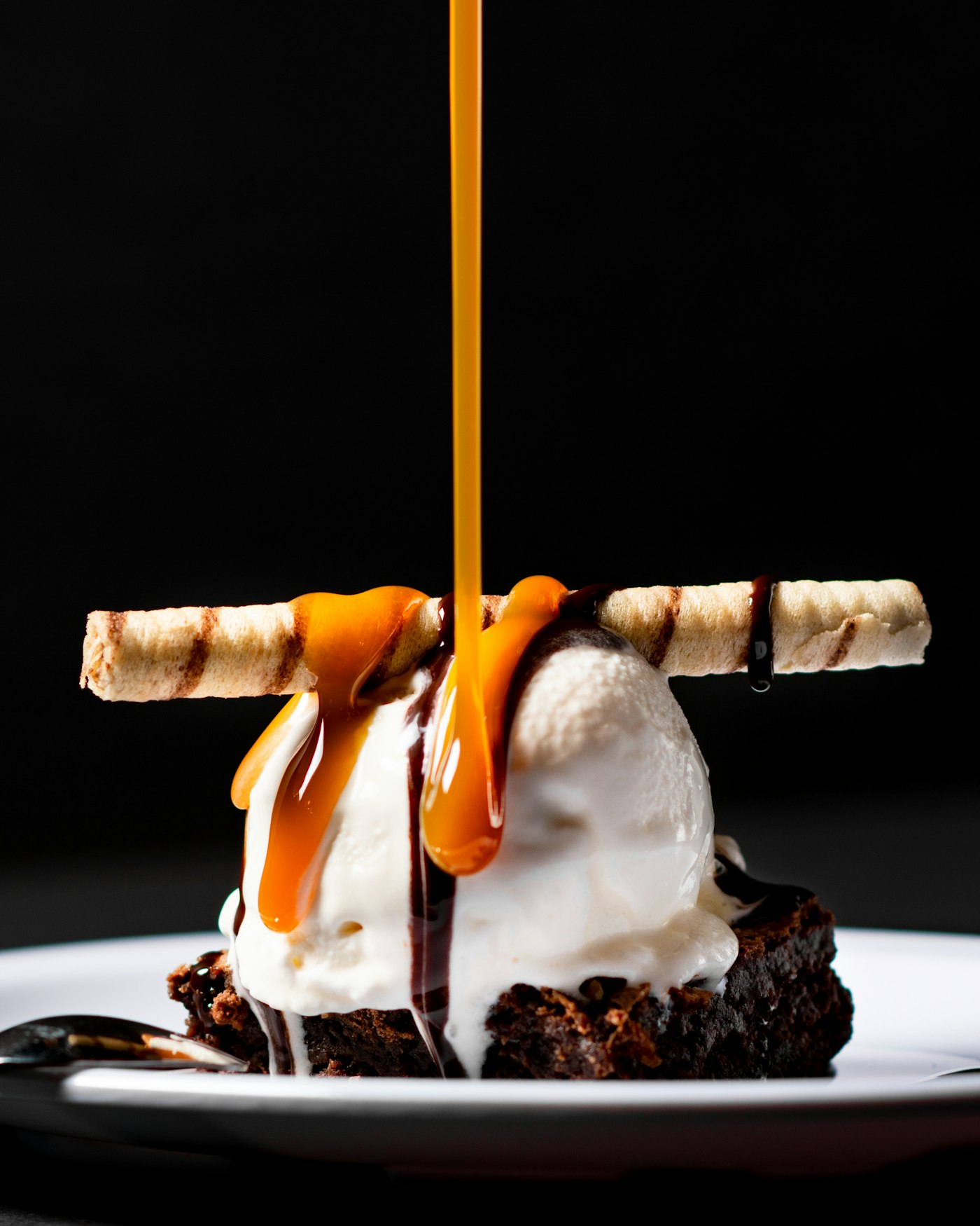 Brownie sundae with caramel poured over vanilla