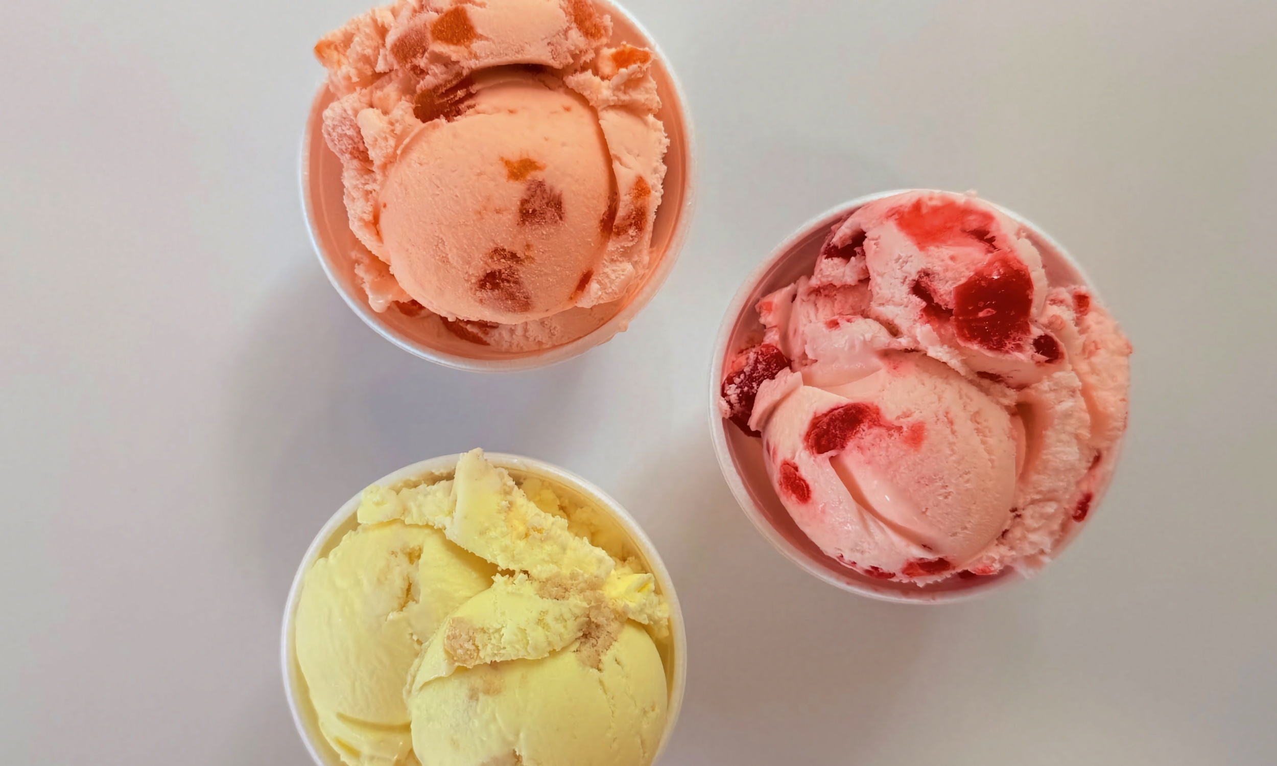 Three cups of our scoops, fruit swirl and butterscotch in white cups