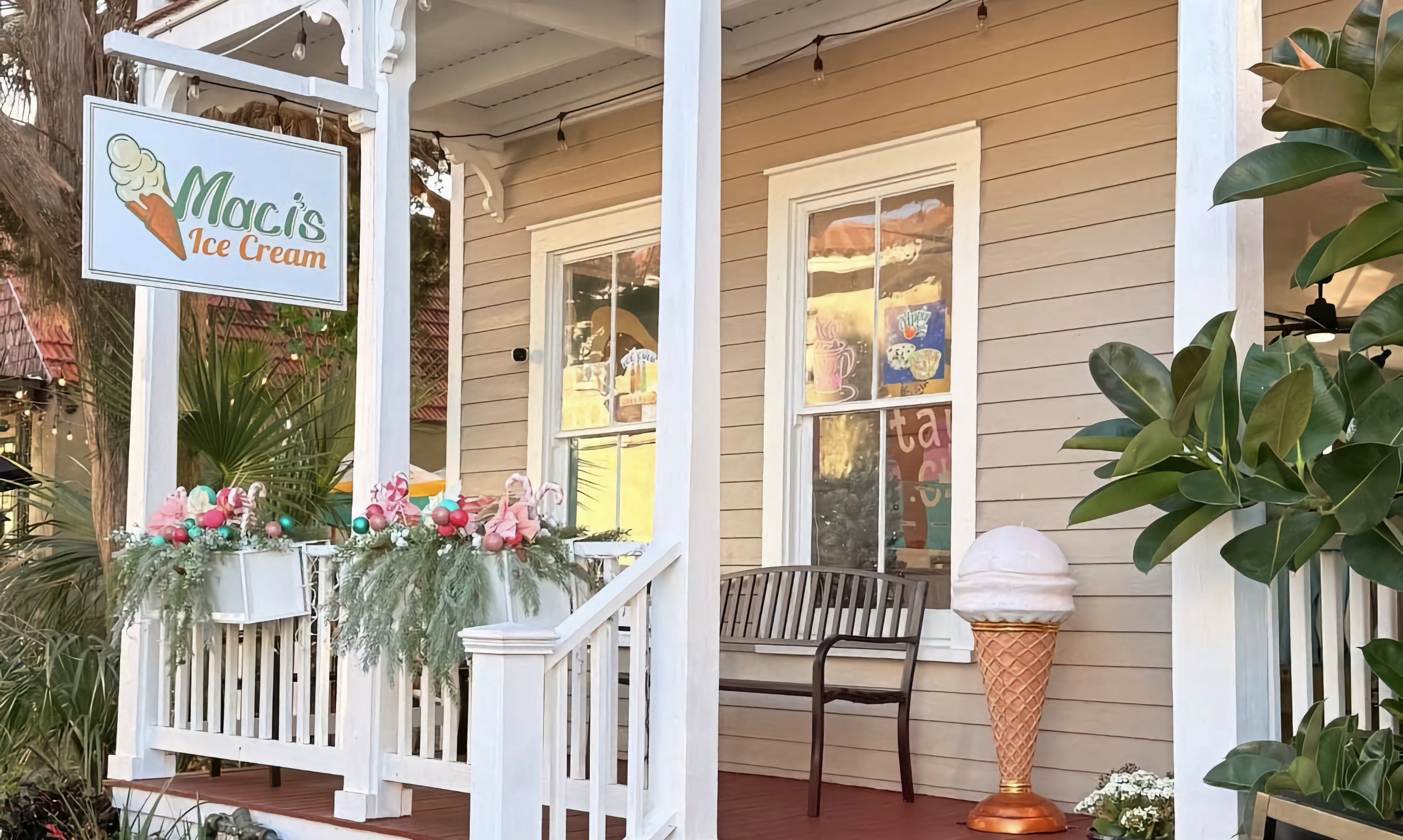 Our tan porch at 32 Charlotte Street, hanging Maci's Ice Cream sign, giant cone, and string lights