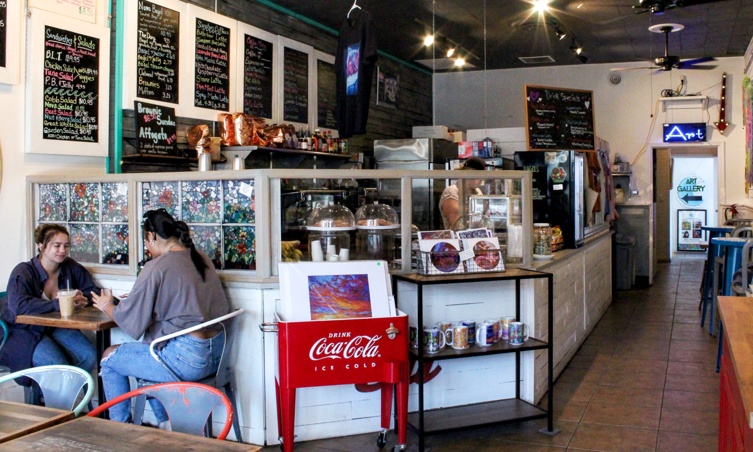 Our coffee bar: whitewashed counter, chalkboard menus, stained glass, and a hallway that leads to the gallery.