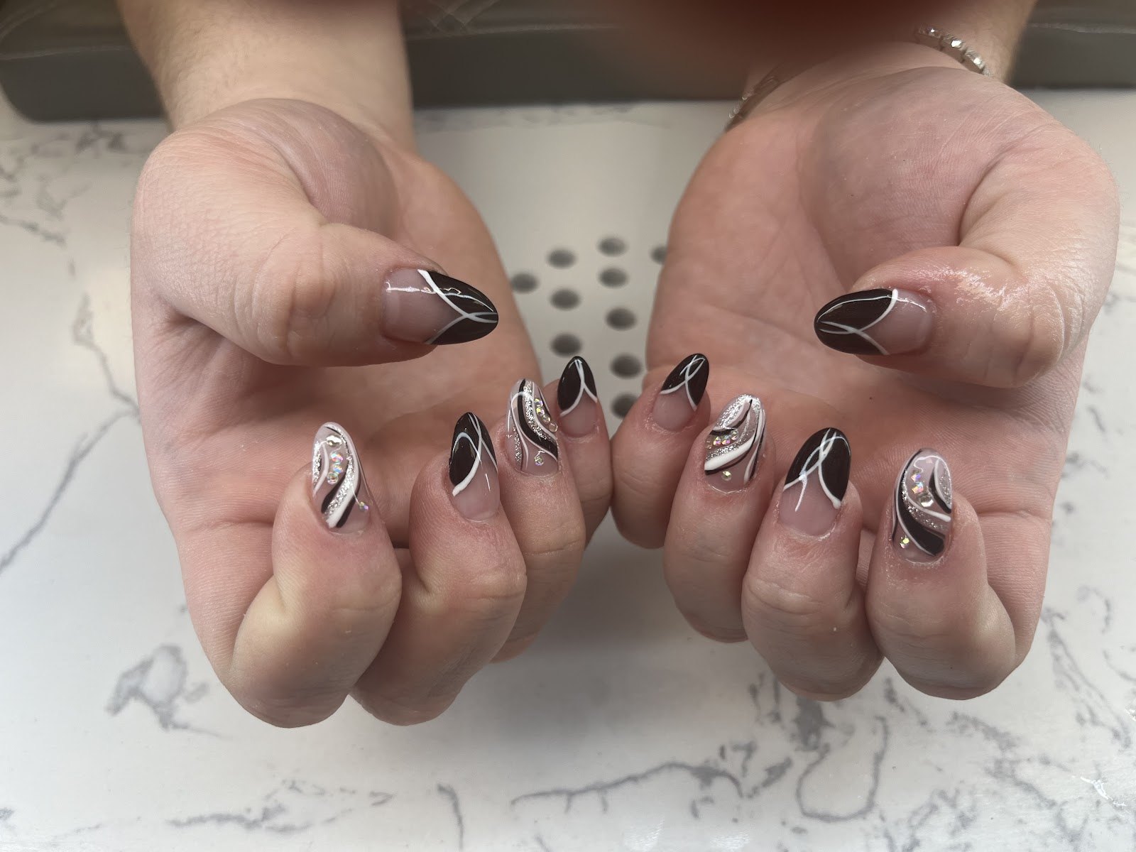 Almond set with black, white, and silver swirl art.