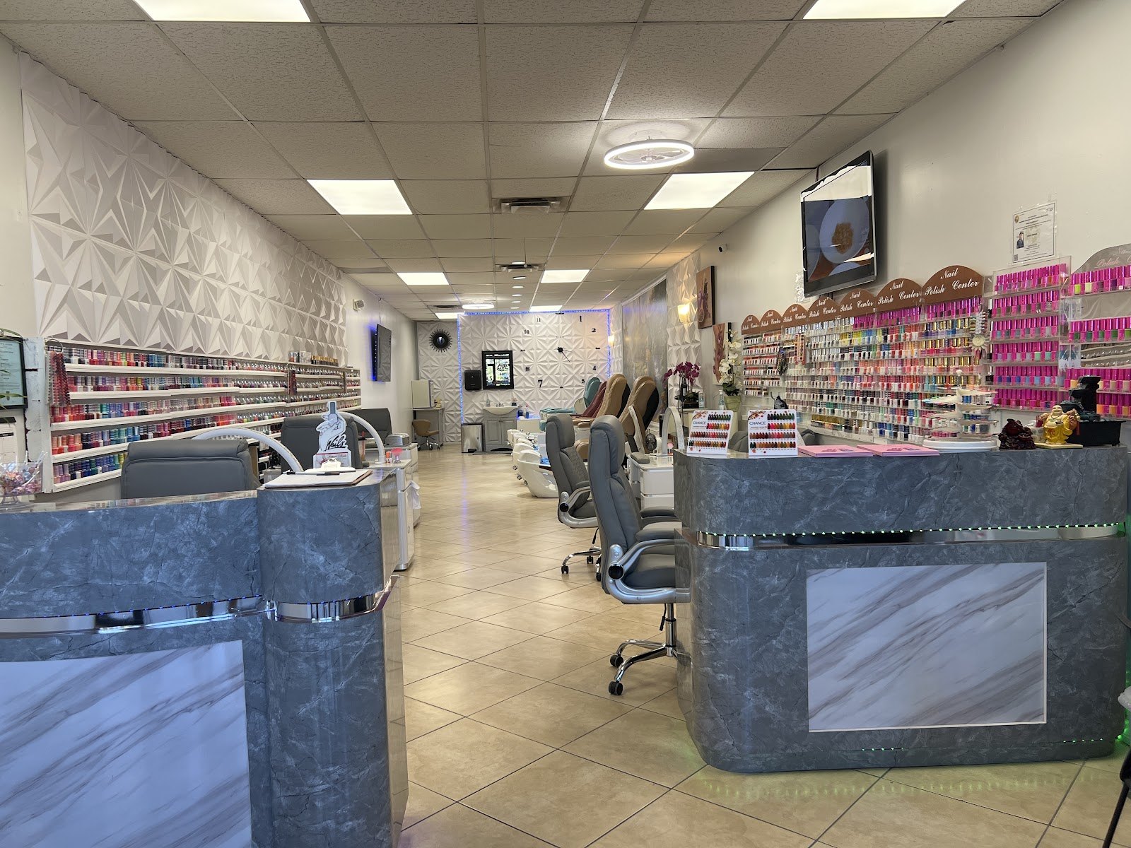 Inside our shop: polish wall, manicure tables, and pedicure chairs in Suite Q.