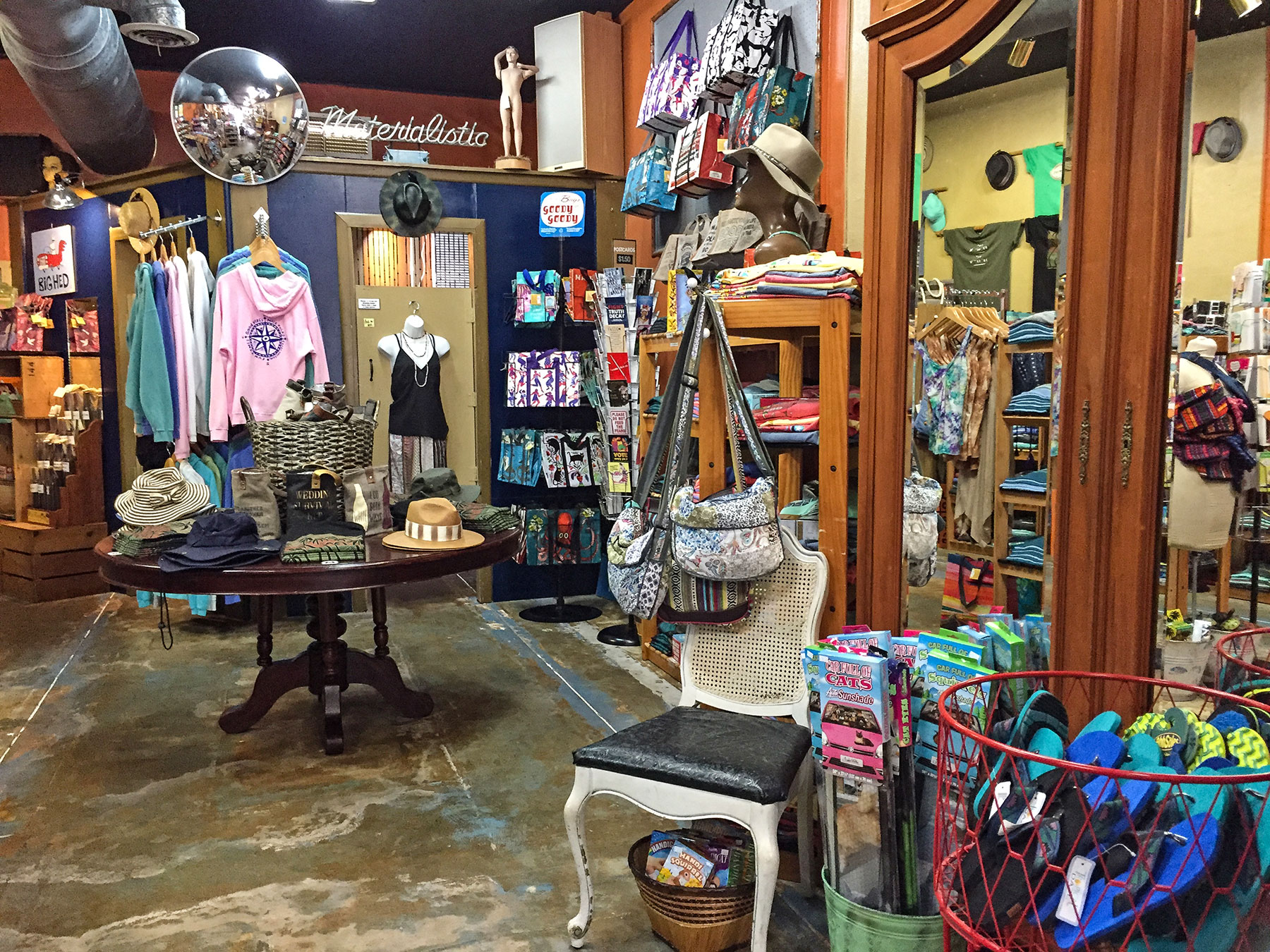 Our shop floor: navy wall, terracotta wall, the Materialistic sign, hats, bags, and flip-flops.