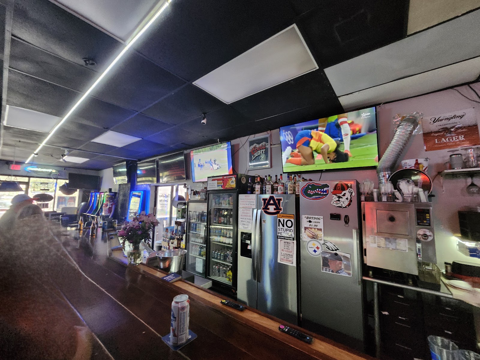 Coolers of bottled beer and the TVs over our bar.