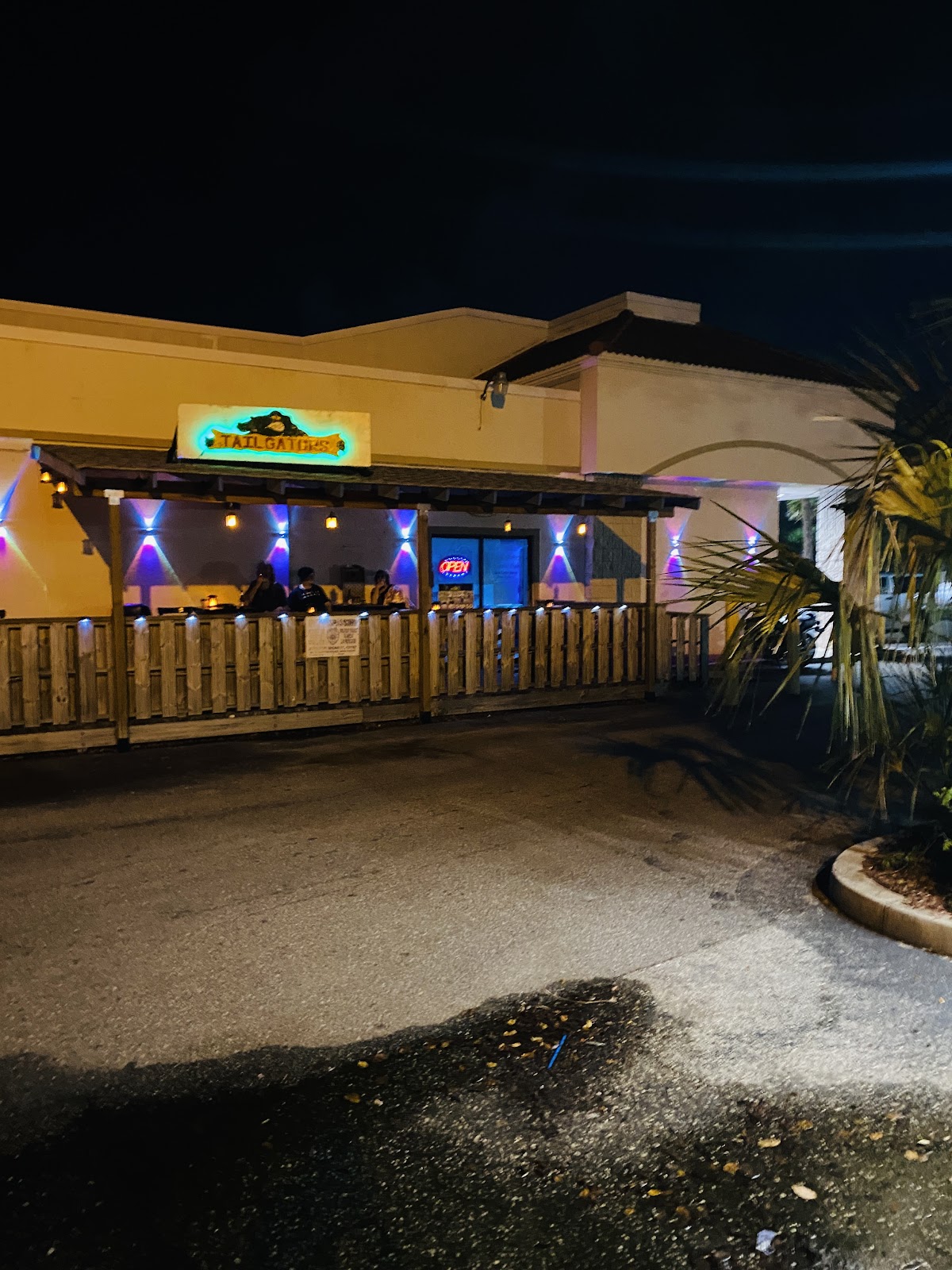 Night shot of our patio, the TailGators sign, and the colored wall lights.