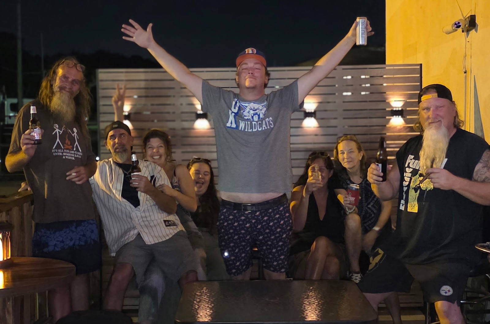 A table of our people on the patio at night, beers up.