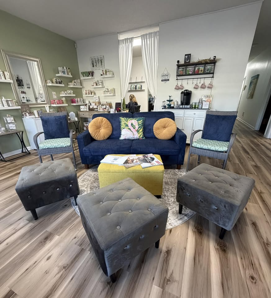Our lounge: navy sofa, yellow ottoman, and product shelves in Suite 9.