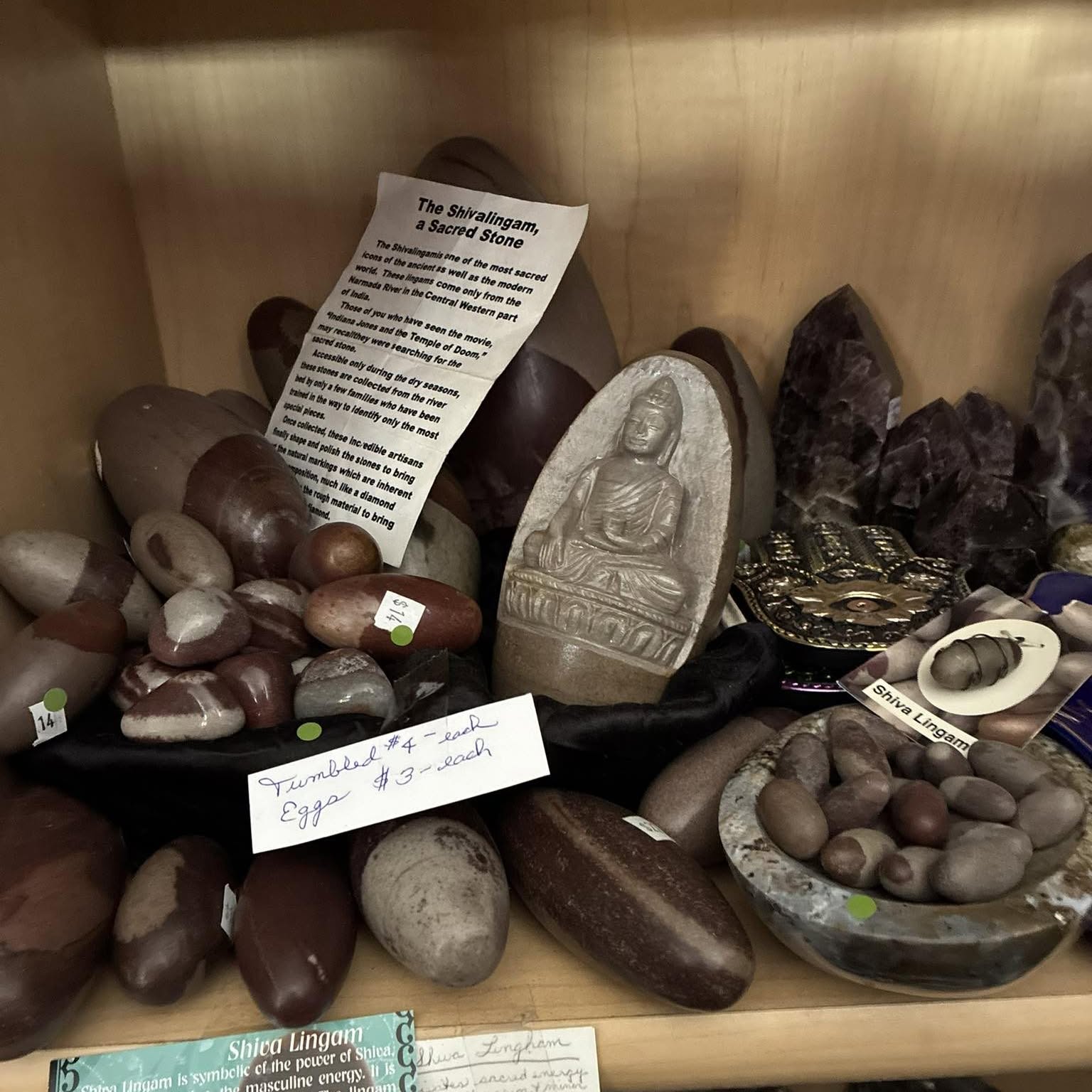 Shiva lingams and amethyst on a wood shelf