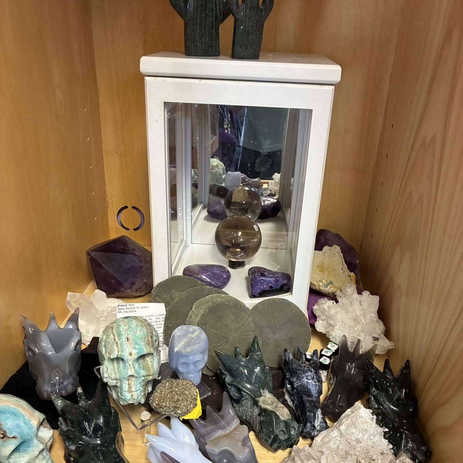 Crystal carvings and quartz on a wood shelf