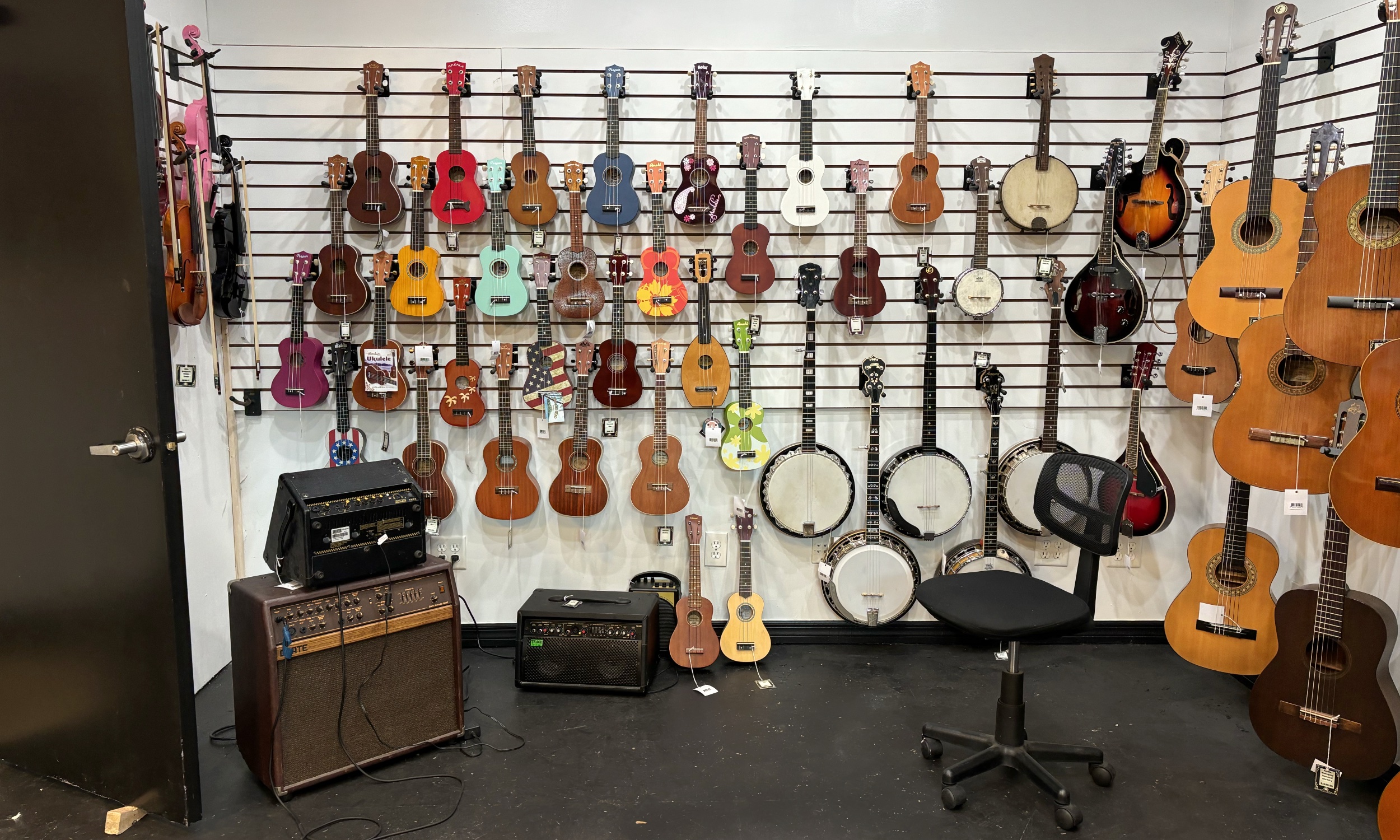 Ukuleles, banjos, and acoustics packed on our slatwall.