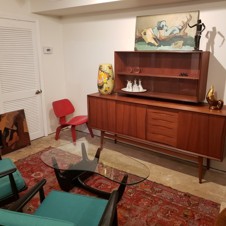 Teak credenza, Noguchi-style glass table, and teal lounge chairs in our showroom.