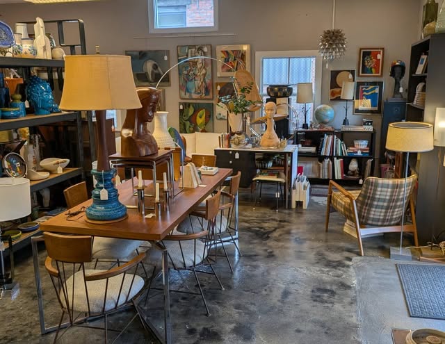 Dining table, wire-base chairs, and ceramics under the pendant.