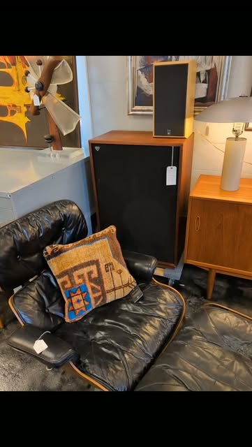 Black lounge chair, teak cabinet, and vintage speakers in the hifi corner.