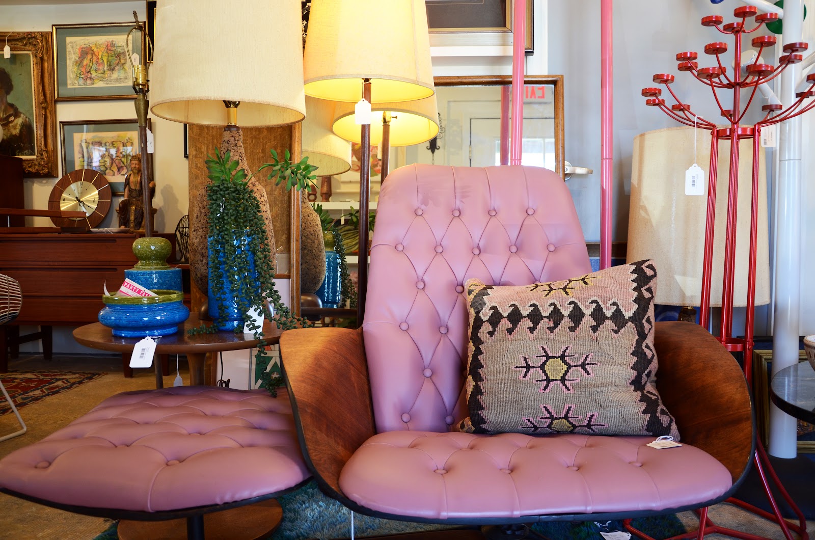 Pink tufted lounge and ottoman with cobalt ceramics and floor lamps.