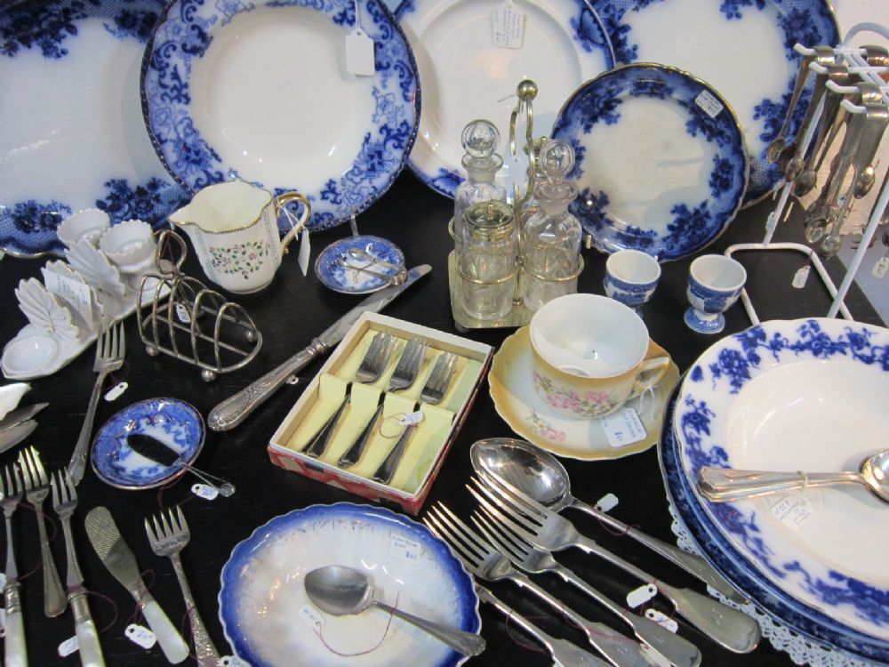 Blue and white plates, floral cups, and silver flatware laid out on our table.