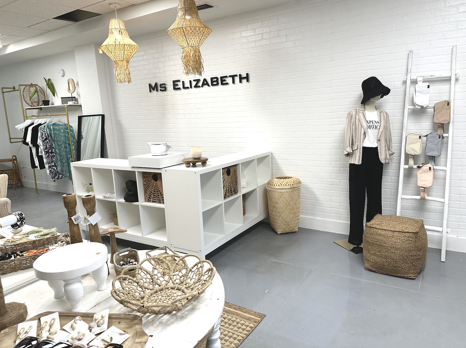 Our checkout, MS ELIZABETH on the white brick, macramé pendants, gold rack.