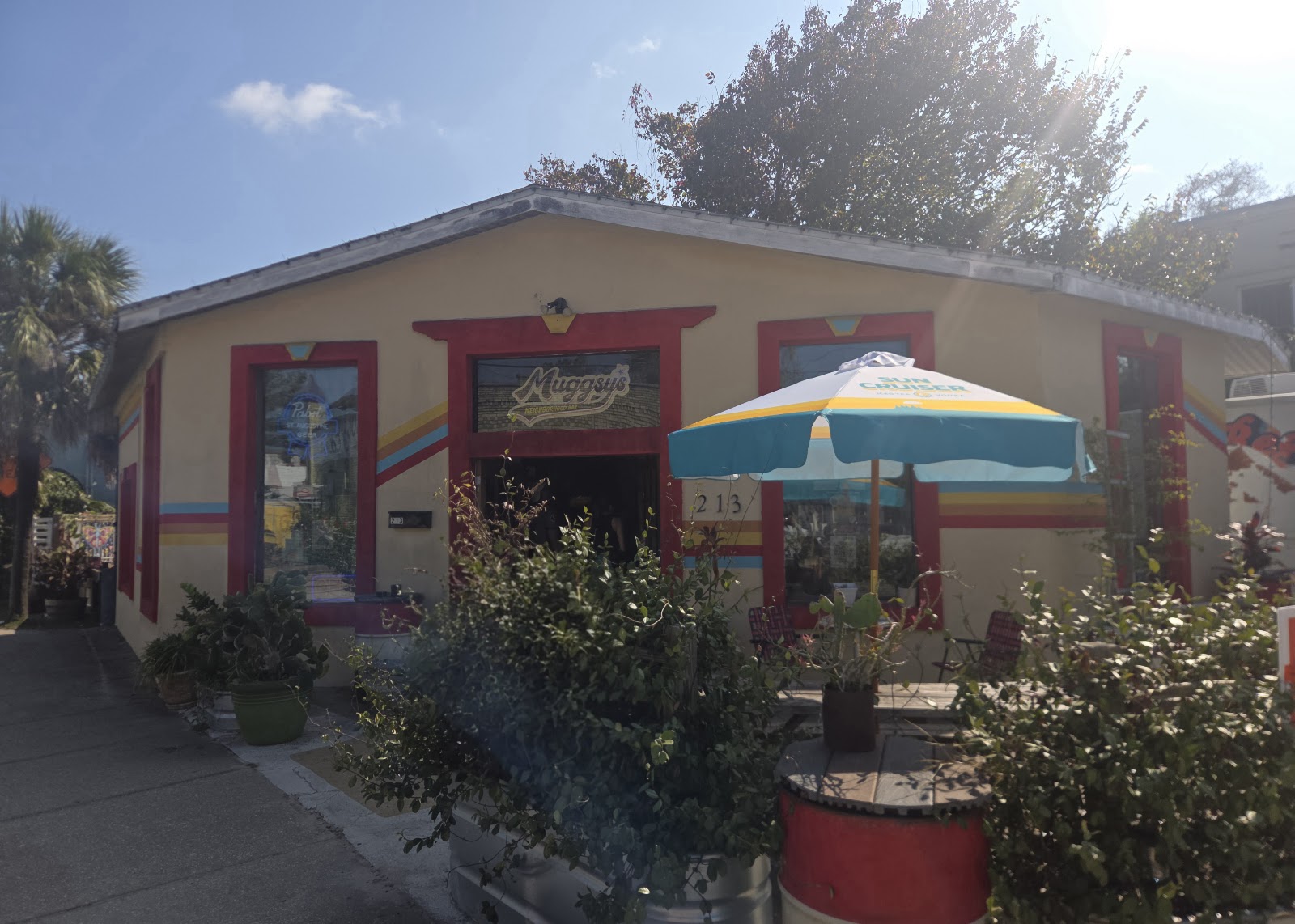 Our red-trimmed door, patio umbrella, and Muggsy's sign at 213 West King