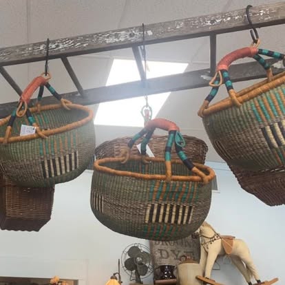 Woven baskets hanging from a wooden ladder inside the shop.
