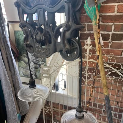 Cast-iron hay trolley pulley hung as a double pendant light.