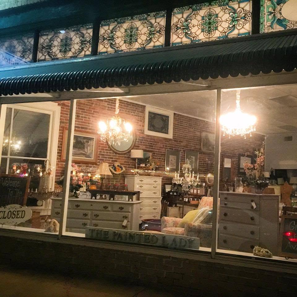 Our window at night, chandeliers lit over painted furniture.