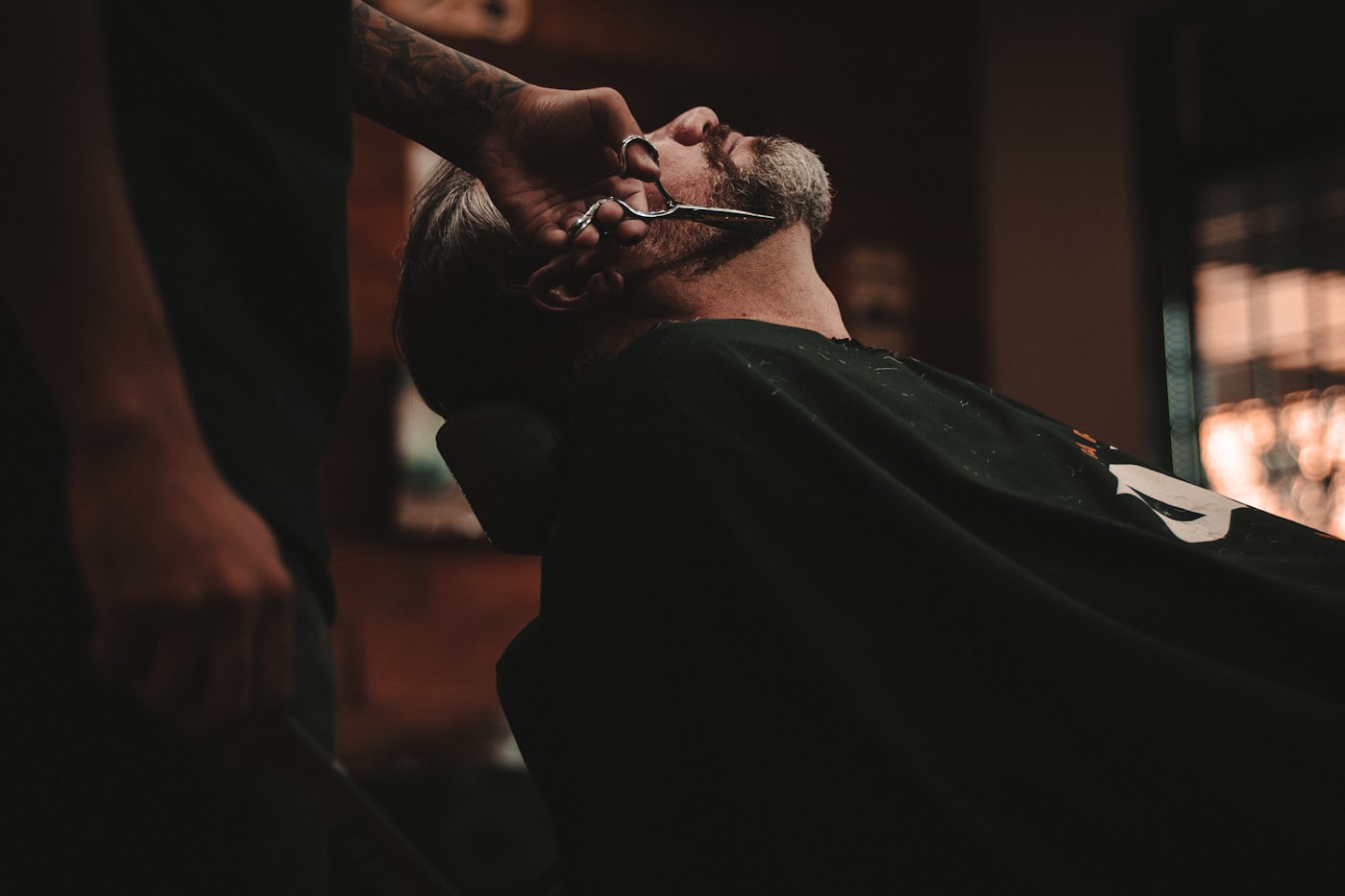 A beard trimmed with shears in the chair.